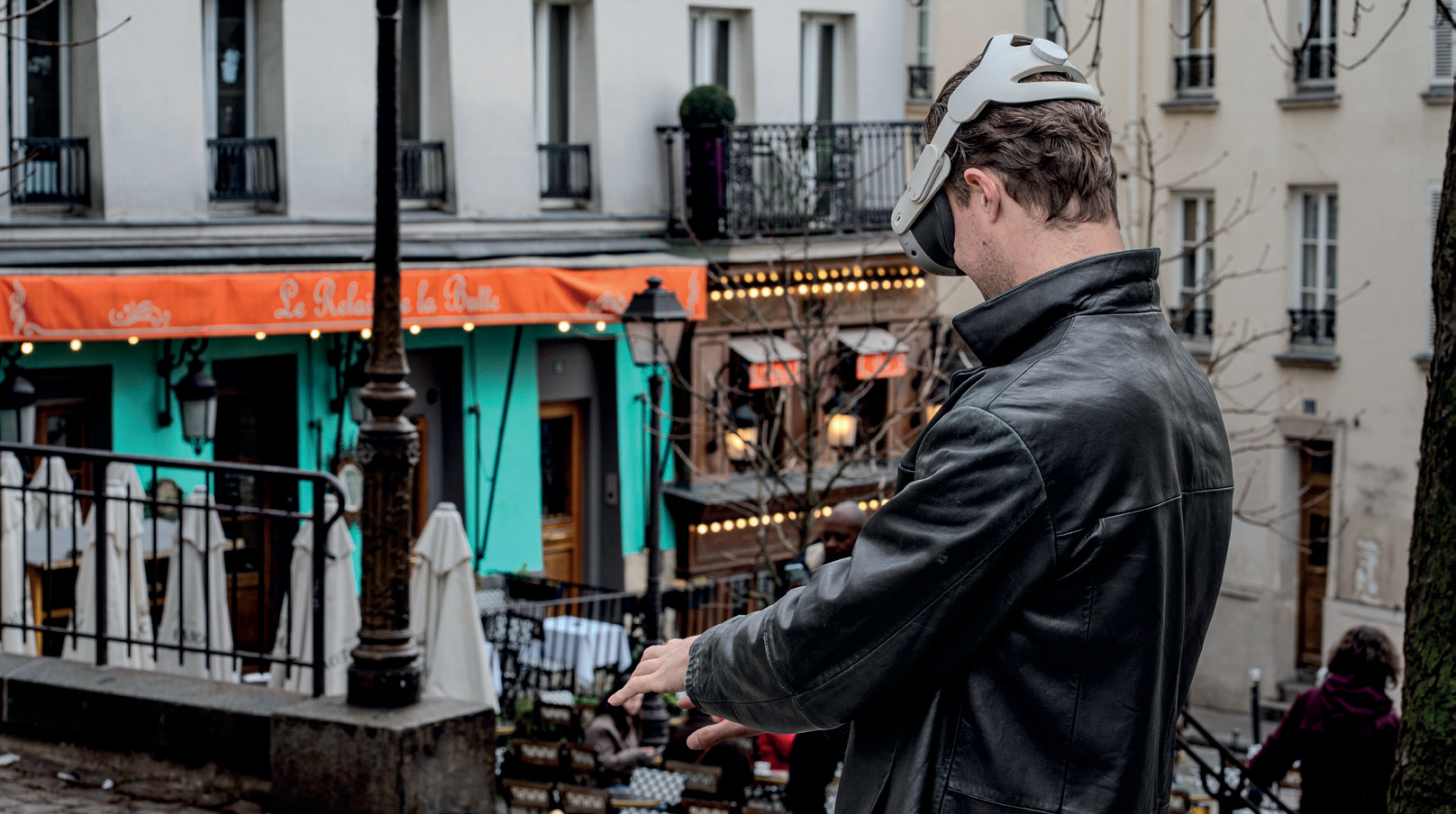 Homme avec casque VR déambulant dans les rues de Montmartre