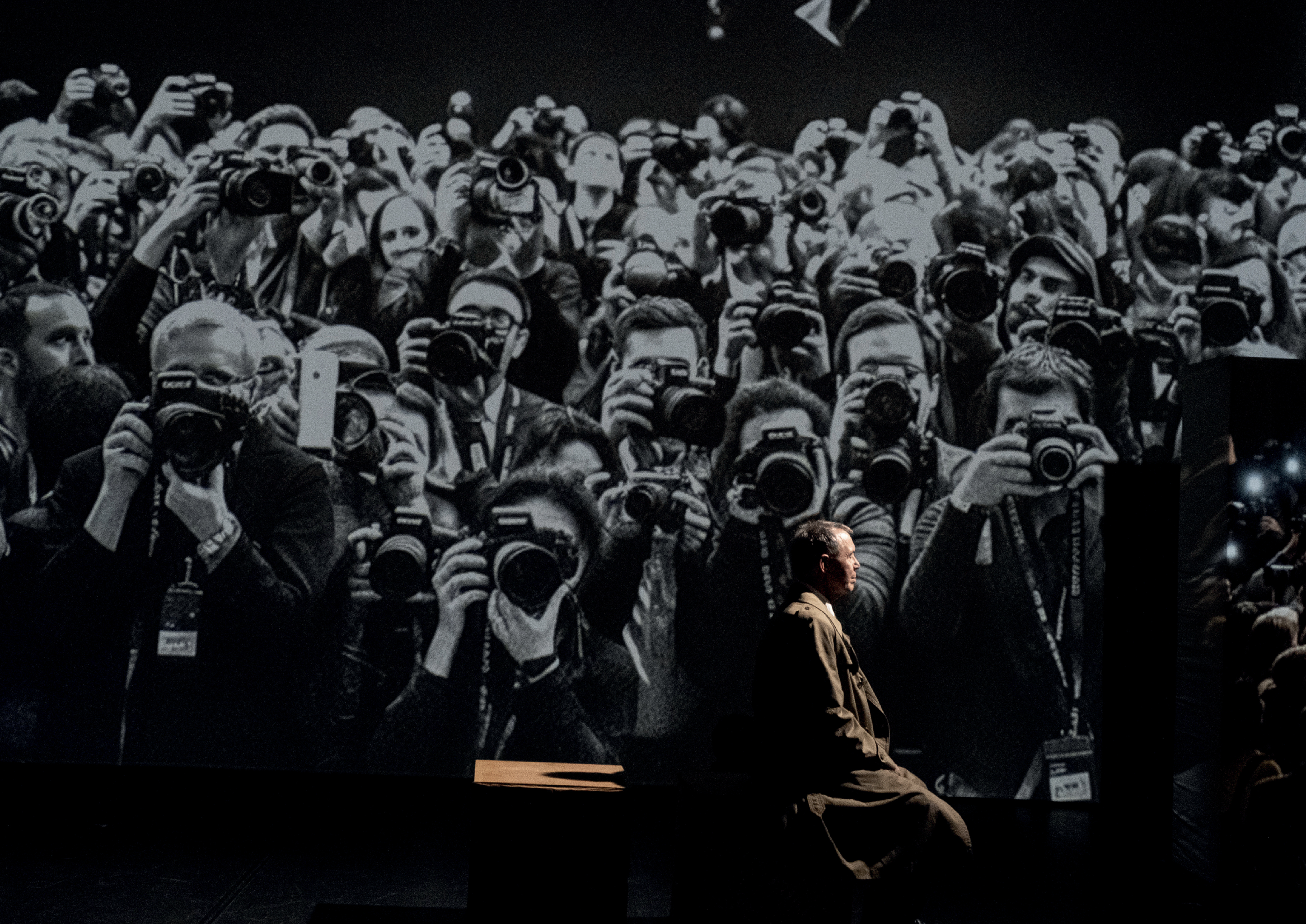 Visiteur devant projection géante de photographes en noir et blanc