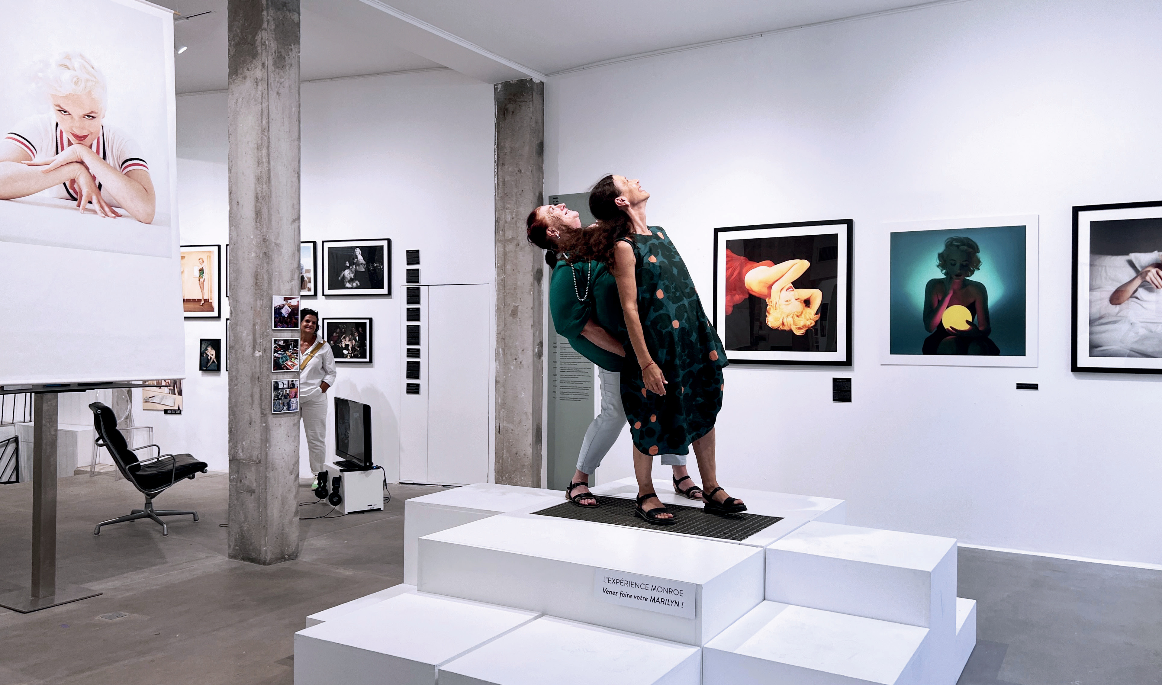 Visiteurs sur podium dans galerie d'art avec photos de Marilyn