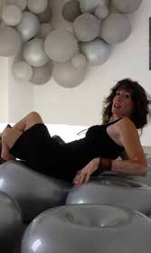 Femme allongée parmi des ballons argentés