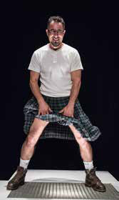 Homme en kilt assis sur scene, performance