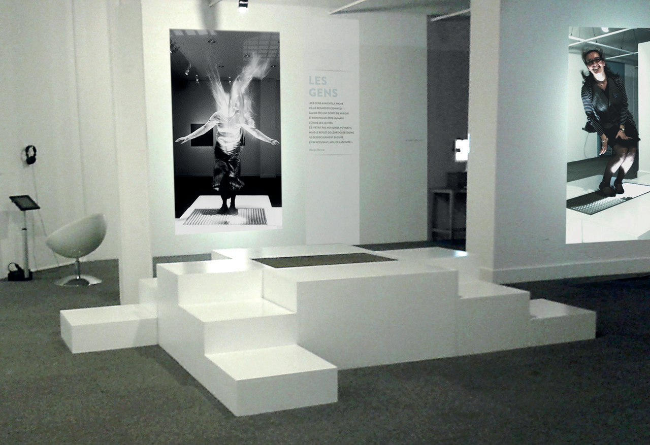 Espace d'exposition avec estrades blanches et photo noir et blanc