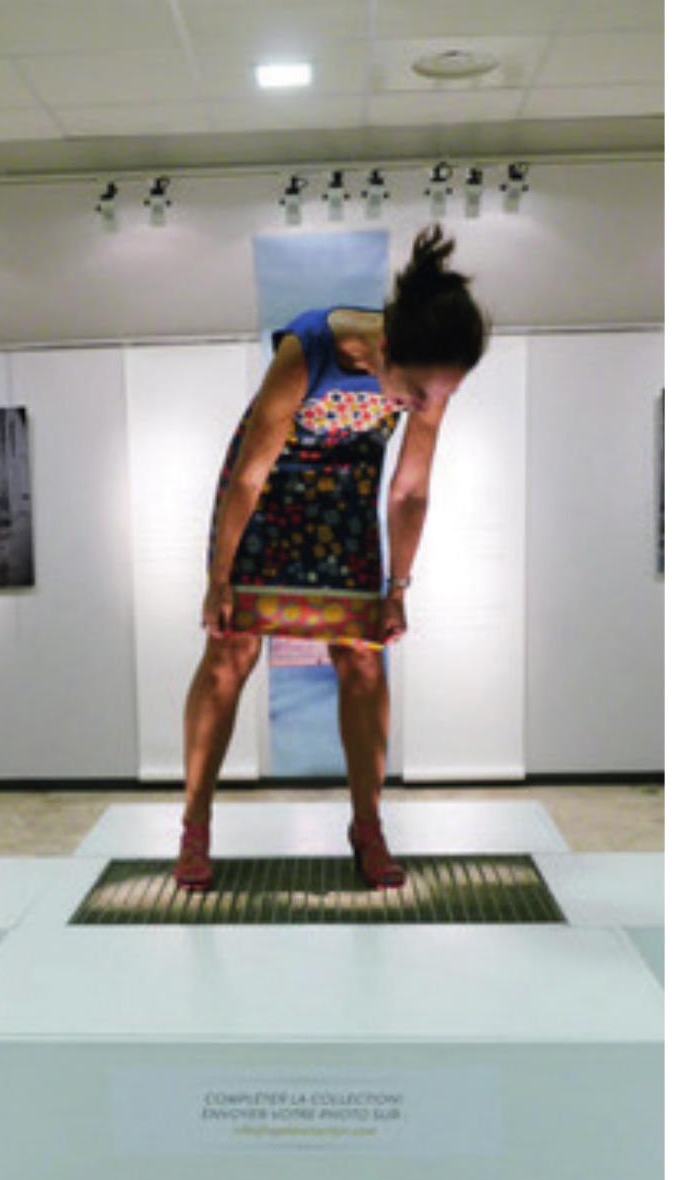 Visiteuse sur un dispositif interactif devant une photographie